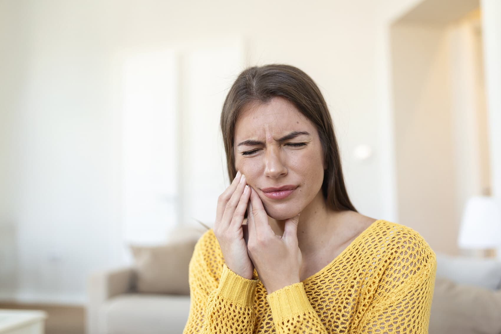 A woman with a toothache needing emergency dental care