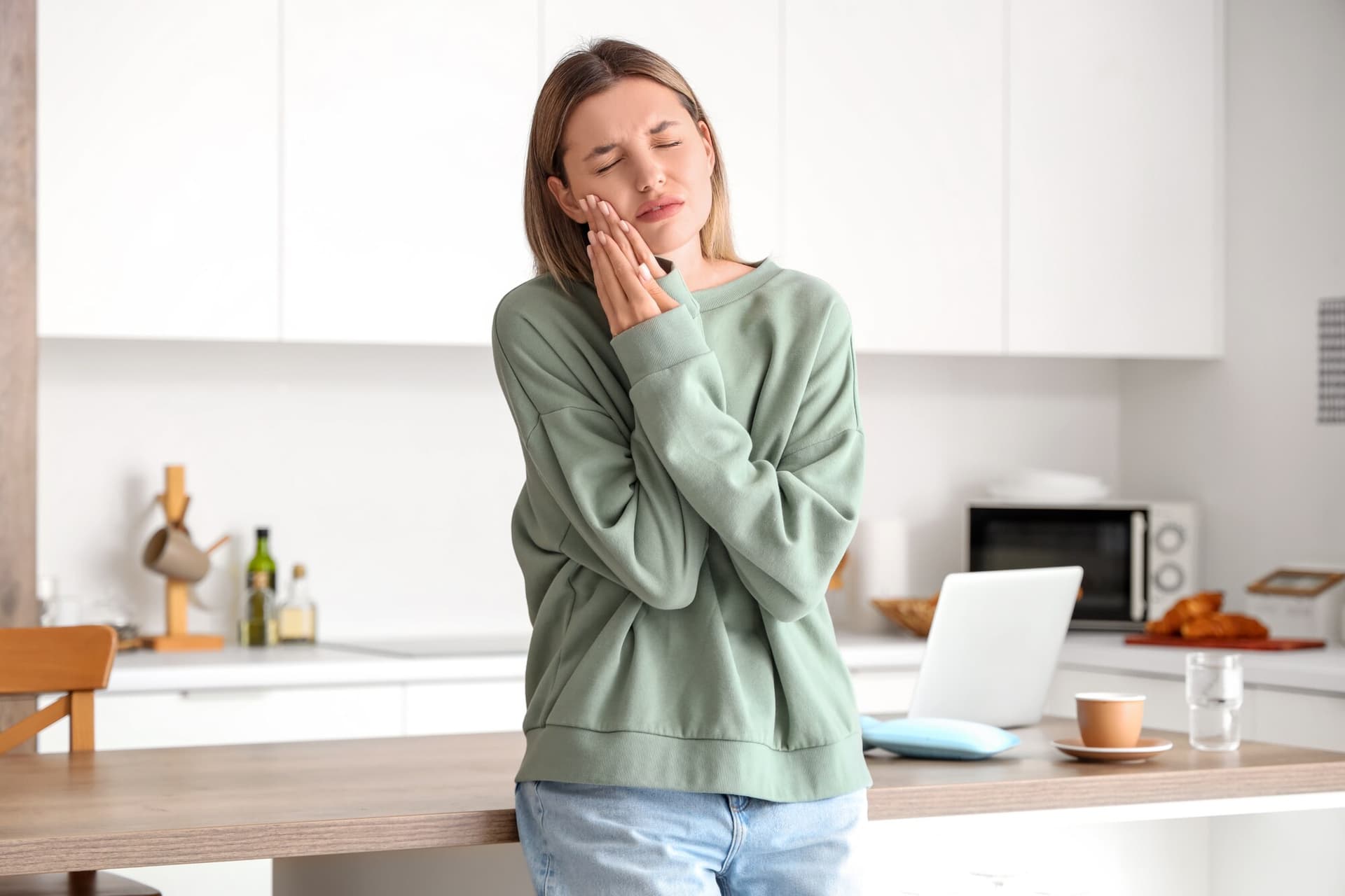 A woman with a toothache in need of emergency dental care